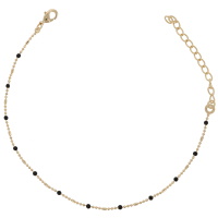 Chaîne de cheville en plaqué or jaune 18 carats et perles en émail de couleur noire. Fermoir mousqueton avec 5 cm de rallonge.