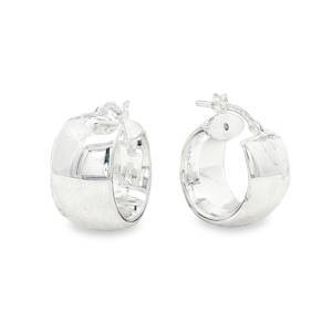 Cette paire de boucles d'oreilles se distingue par son design robuste et audacieux. Conçues dans un esprit huggie large, elles offrent une présence visuelle forte tout en restant élégantes. Ces créoles de type anneaux larges avec une forme bombée et généreuse sont en argent 925/000 offrant une brillance blanche et pure.