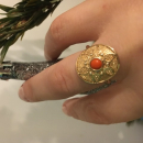 Bague surmontée d'une pastille ronde représentant une fleur en plaqué or jaune 18 carats sertie d'une pierre synthétique de couleur rouge corail. Rond  Adolescent Adulte Femme Fille Fleurs Indémodable 